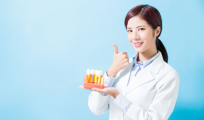 Diş hekimi, diş implantı modelini göstererek doğru bilinen yanlışları açıklıyor.