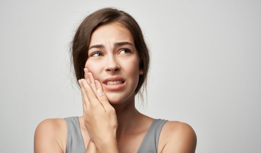 Diş implantı sonrası ağrı yaşayan kadın hasta