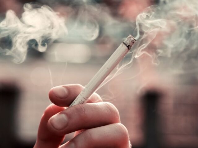 İmplant Sonrası Sigara Kullanımı Sigara içen bir kişi ve yükselen duman, diş implantı sağlığına zarar verebilir.